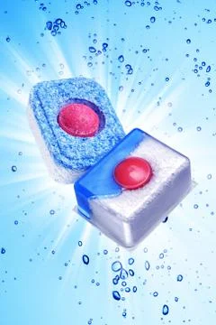 Two dishwasher detergent tablet under blue water Stock Photos