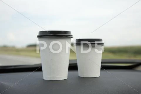 Two Disposable Cups Of Coffee On A Car Dashboard