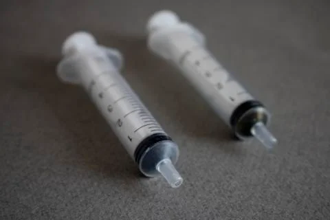 Two disposable syringes on a gray background Stock Photos