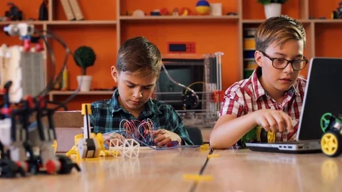 Two dissapointment boys with screwdrivers trying to assemble robotic machines Stock Footage 82489564