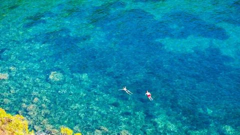 Two divers dive on the surface of the sea in a beautiful bay on a summer day. Foto stock