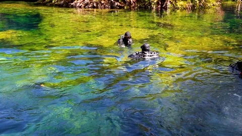Two divers in full uniforms are preparing to dive into the underwater cenote Stock Footage 90548121