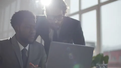 Two Diverse Coworkers Using laptop and Celebrating Business Success Stock Footage 135558832