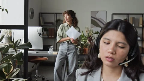 Two Diverse Customer Support Agents woth Headsets Working in Office Stock Footage 343622306