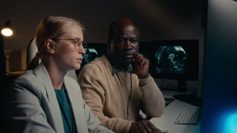 Two Diverse Cyber Security Specialists Discussing Issue with Code Stock Footage 288791821