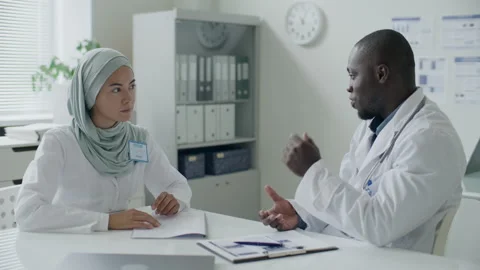 Two Diverse Doctors Having Professional Discussion in Medical Office Stock Footage 313810305