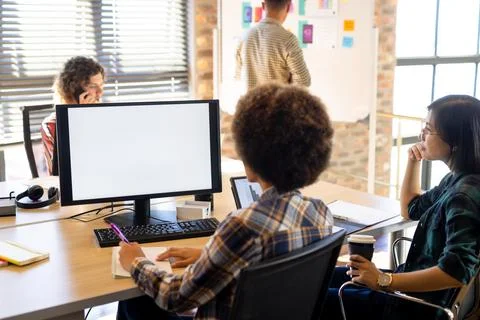 Two diverse female creatives at computer with copy space on screen, having video Stock Photos