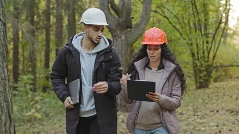 Two diverse forestry engineers in hardhats with tablet, Indian man and oriental Stock Footage 165422609