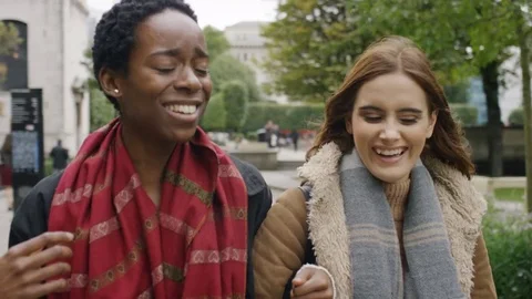 Two diverse friends in the city talking and walking as the camera follows them Video stock 80326326