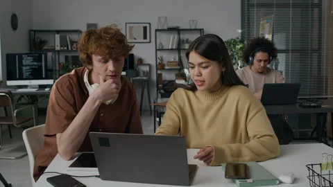 Two Diverse Gen Z Programmers Discussing Work Tasks Pointing at Laptop Screen Stock Footage 299292354