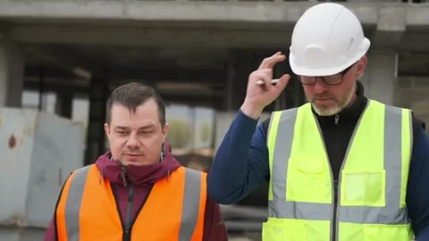 Two diverse professional workers engineers wearing safety uniform and hardhats Stock Footage 274412397