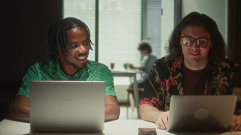 Two Diverse Programmers Discussing Data on Laptop in Dark Office 库存影片 340495920