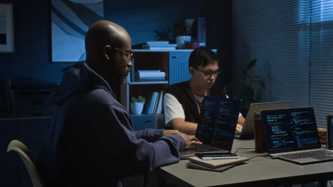 Two Diverse Software Testers Working on Laptops in Office of IT Company at Night Stock Footage 329614093