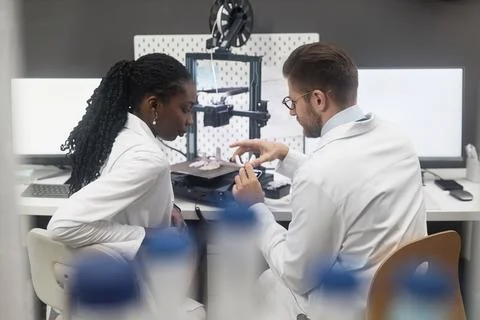 Two Diverse Technicians Looking at Produced 3D Model Foto stock