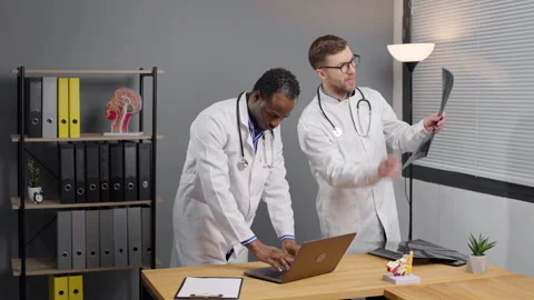 Two doctors analyzing patient test results on laptop with x-ray test Video stock 276222748