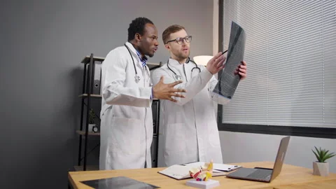 Two doctors analyzing patient x-ray test results 動画素材 276221448