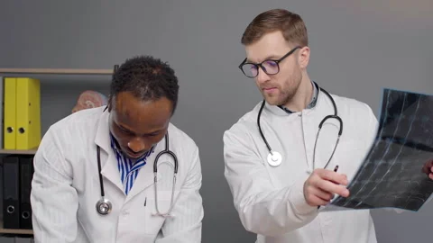 Two doctors analyzing test results on x-ray Stock Footage 276223010