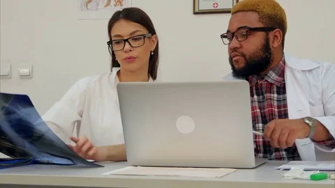 Two doctors analyzing X-ray image while using computer Vídeos de archivo 71772282