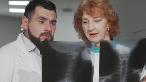 Two doctors analyzing x-ray scans with focused determination Stock Footage 311985060