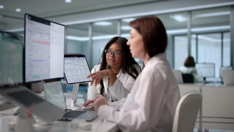 Two Doctors And Nurse Discuss Patient Records Using Laptop Stock Footage 343890662