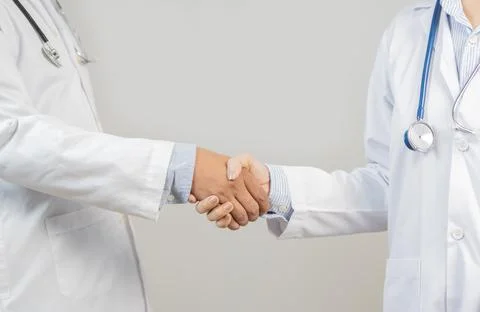 Two doctors are shaking hands in meeting room or medical office and support.. Foto stock