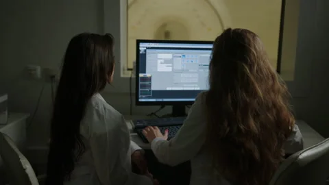 Two doctors are sitting at the computer in the X-ray laboratory Stock Footage 208006960