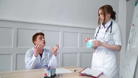 Two doctors argue whether the mask helps to protect against viral infections. Stock Footage 128997132