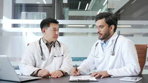 Two doctors collaborating in office, discussing medical strategies and patient  Stock Footage 290895593