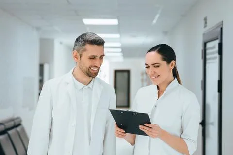 Two doctors conferring over a case standing at hospital corridor. teamwork .. Foto stock