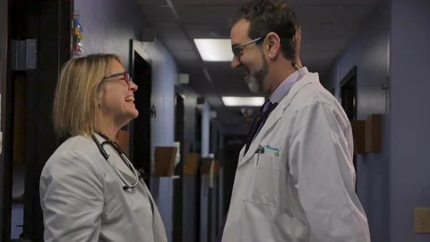Two doctors congratulating each other on a job well done in a hospital Stock Footage 101448424