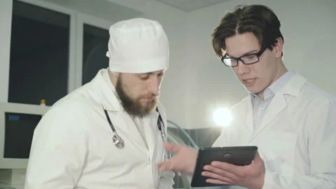 Two doctors consulting using tablet in the clinic. 4K Video stock 87948180