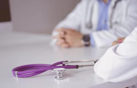 Two doctors discussing and working together in a medical office Stock Photos