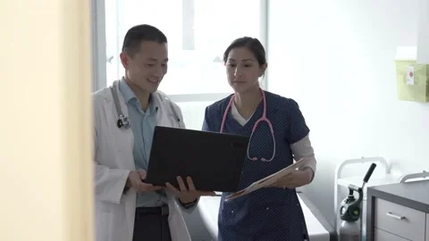 Two doctors discussing medical notes using laptop Stock Footage 220944605
