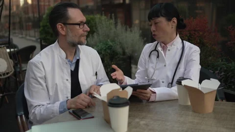 Two doctors discussing patient case during lunch break Stock Footage 333325474