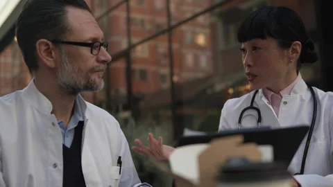 Two doctors discussing patient case during lunch break Stock Footage 333325477