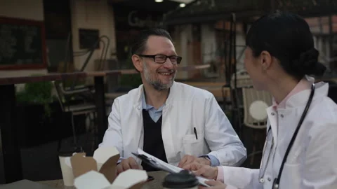 Two doctors discussing patient case during lunch break Stock Footage 333325609