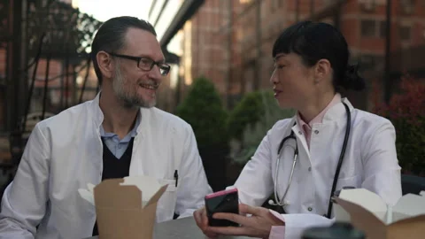 Two doctors discussing patient case during lunch break Stock-Footage 333325631