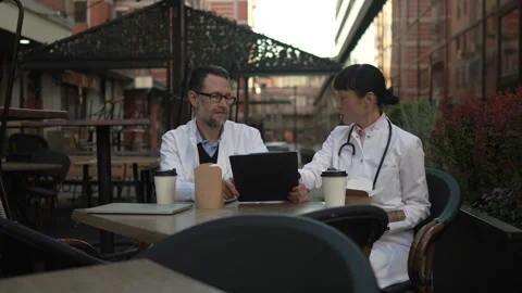 Two doctors discussing patient case during lunch break Stock Footage 333325790