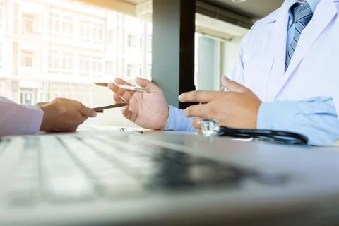 Two doctors discussing patient notes in an office pointing to a clipboard w.. Foto stock
