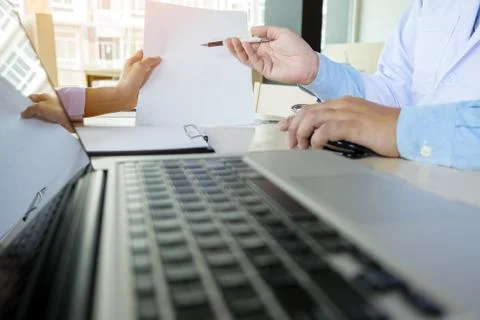Two doctors discussing patient notes in an office pointing to a clipboard w.. Foto stock