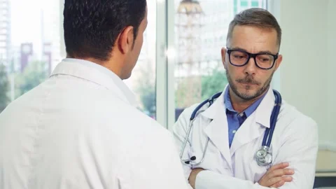 Two doctors engaged in a serious discussion Stock Footage 311990944