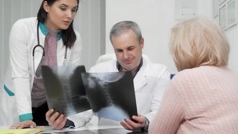 Two doctors examining x-ray scans of a senior patient Stock-Footage 140355925