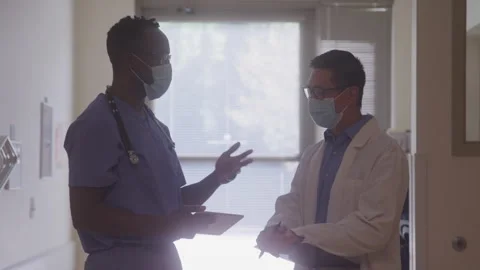 Two Doctors Exchanging Notes In The Hallway Stock Footage 219593919