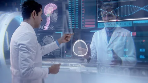 Two doctors having a futuristic video conference analyze a patient's MRI. Video stock 106696057