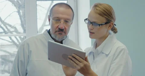 Two doctors having professional talk using touch pad Stock Footage 52375935