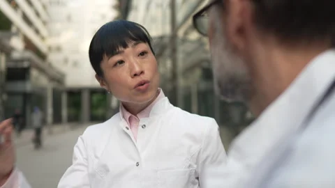 Two doctors having a serious discussion outdoors Stock Footage 333325884
