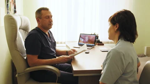 Two doctors holding and talking about a file. Doctors discussing and working Stock Footage 174315662