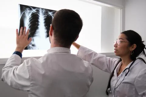 Two doctors interpreting a ribs x-ray image. Stock Photos