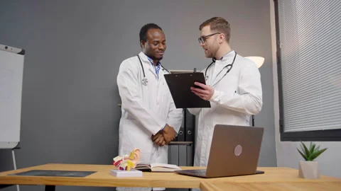 Two doctors in Lab Coats Analyzing Data on tablet Stock-Footage 264980150