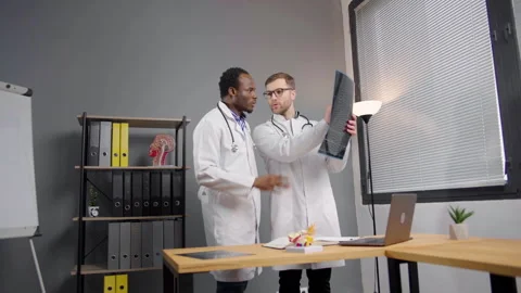 Two doctors in Lab Coats Analyzing X-ray image of patient Video stock 264981845